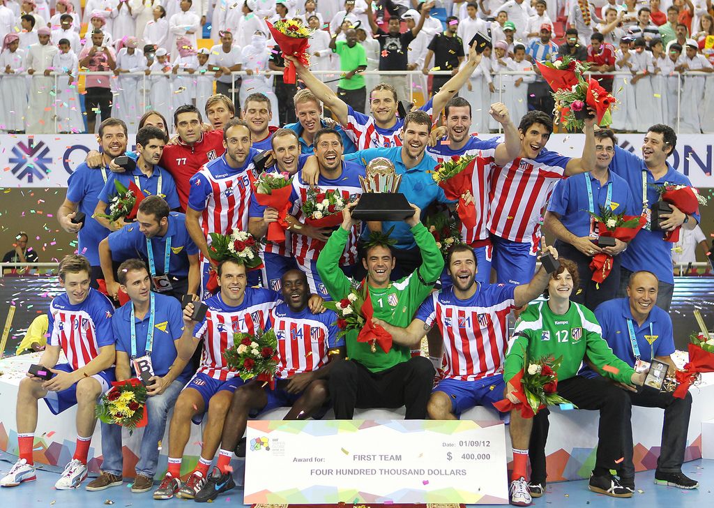 In this image, we can see people wearing sports dress and one of them is holding an award and some...