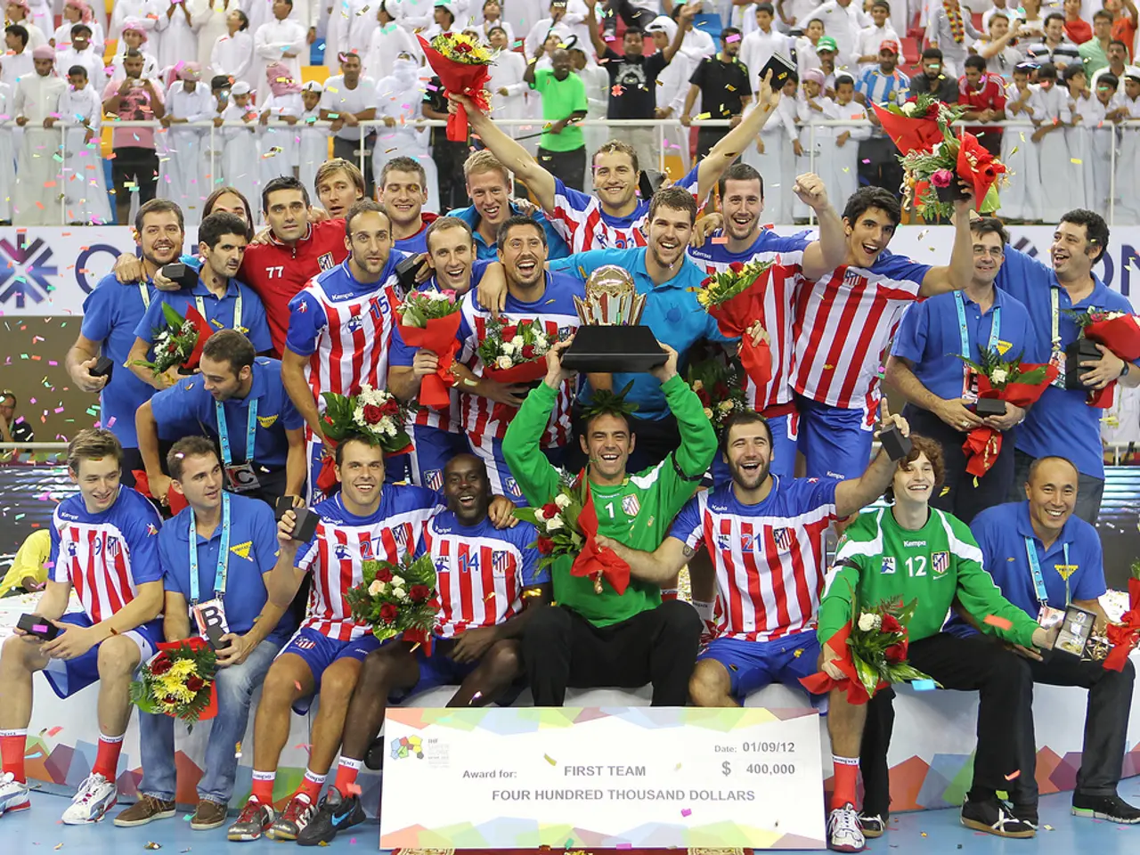 In this image, we can see people wearing sports dress and one of them is holding an award and some...